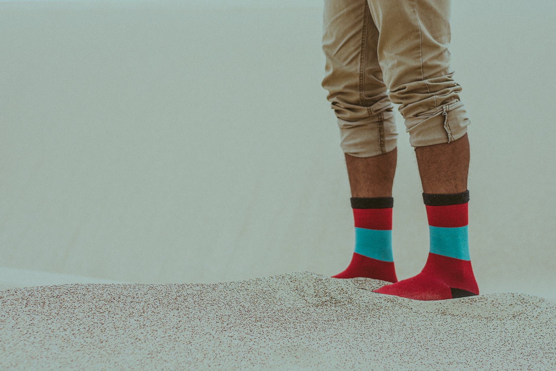 person wearing red socks walking on sand