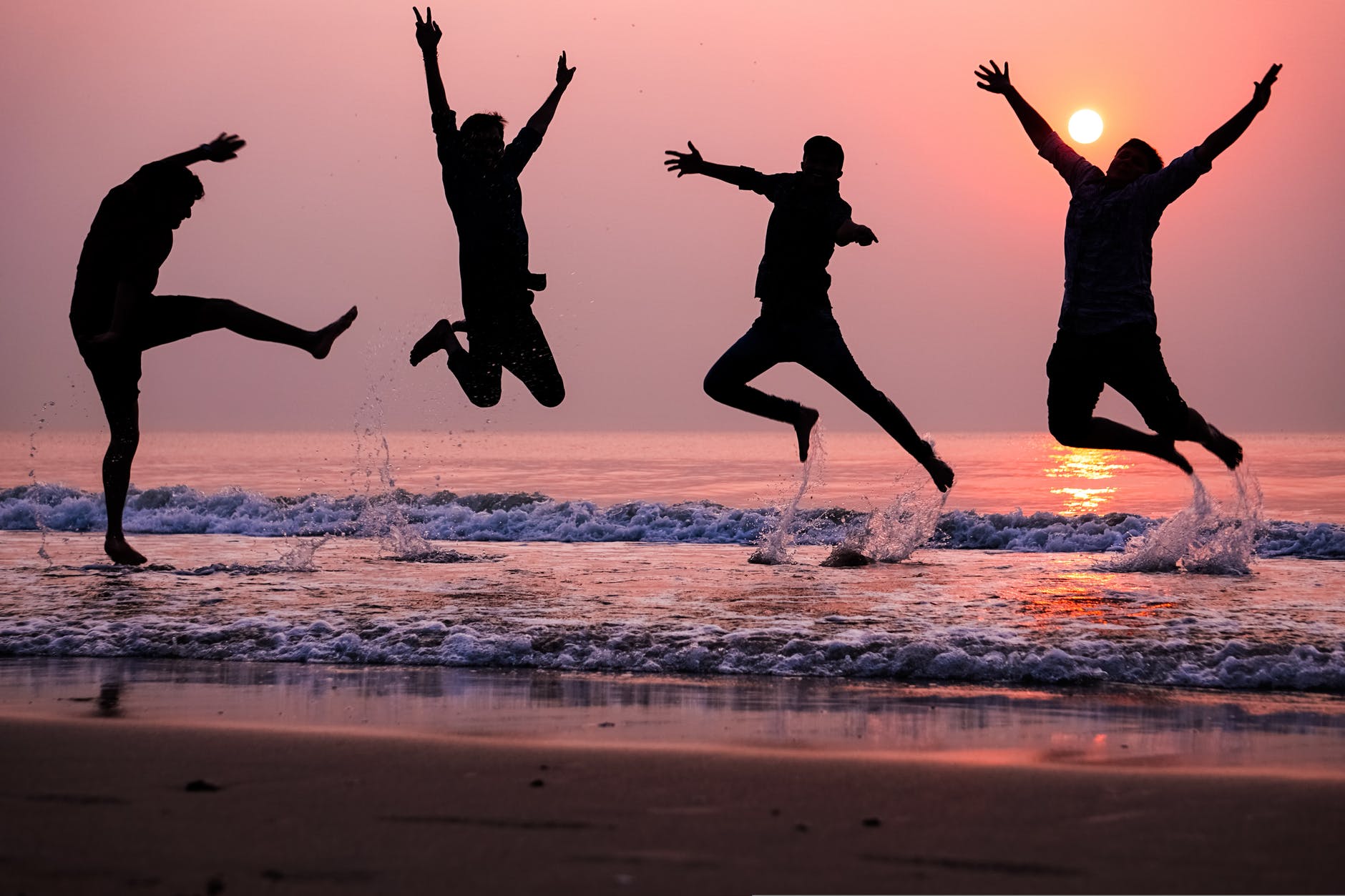 photo of people doing jump shot on beach