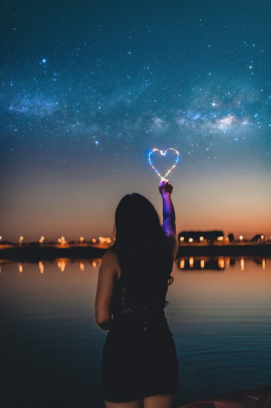 woman holding a heart shape light