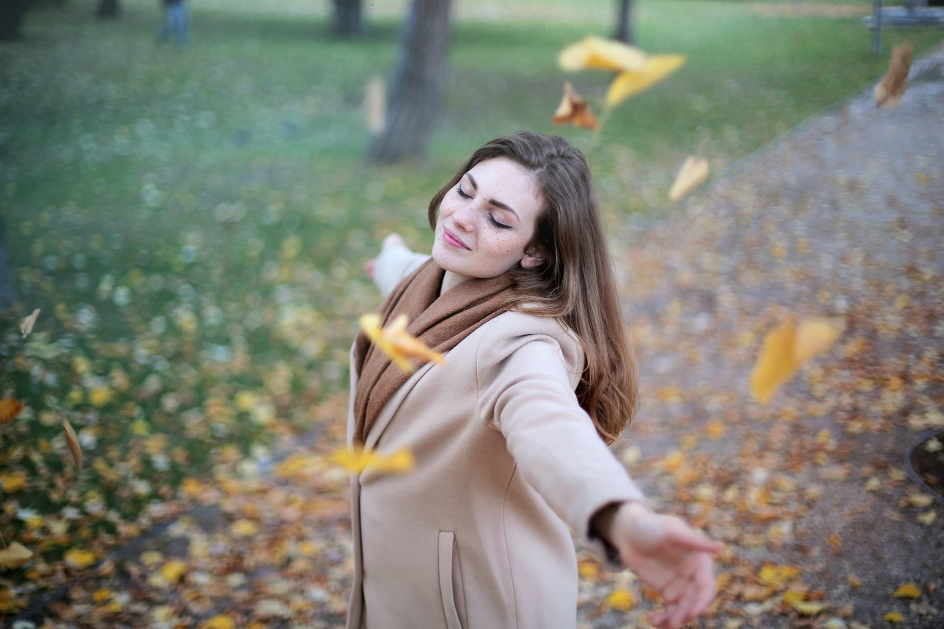 woman open arms while closed eyes smiling photo