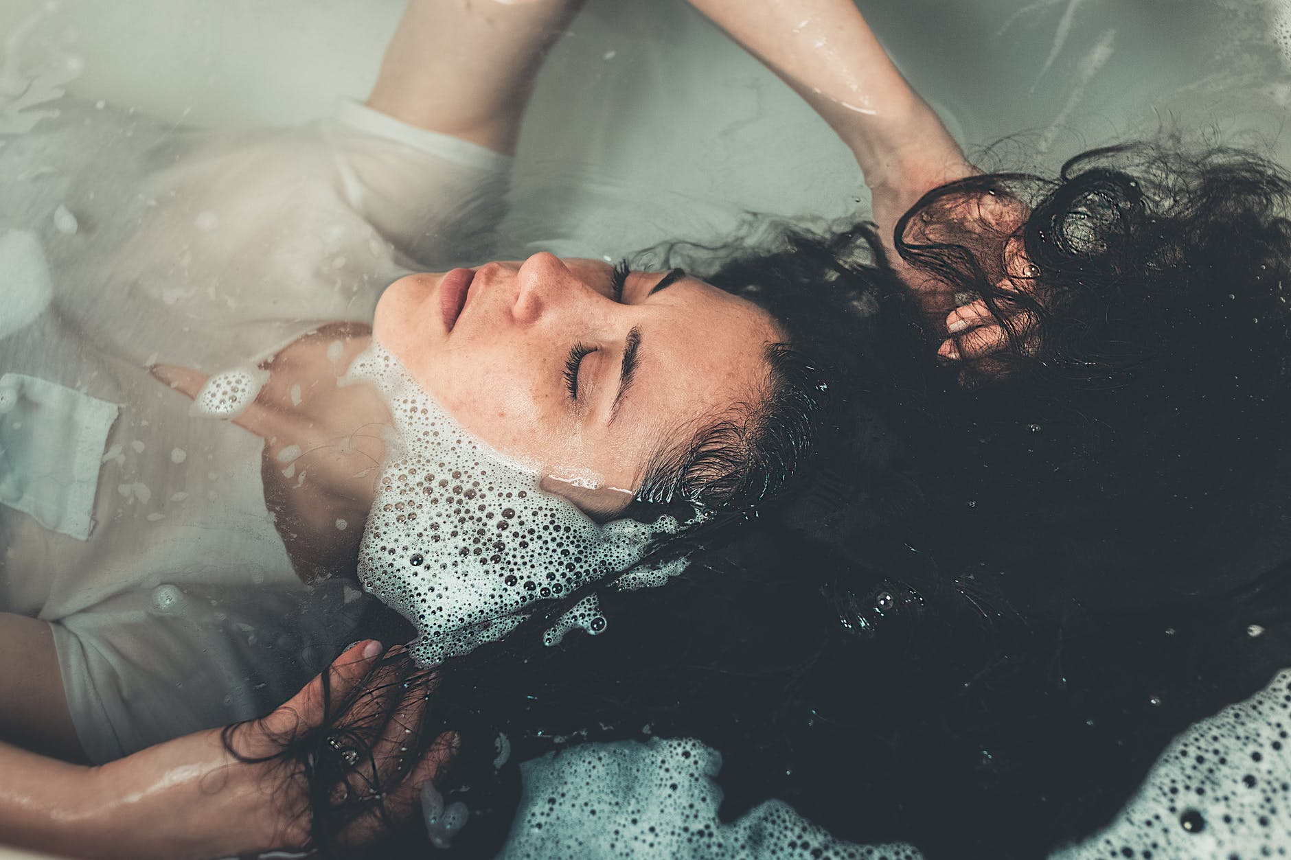 woman lying in bathtub filled with water