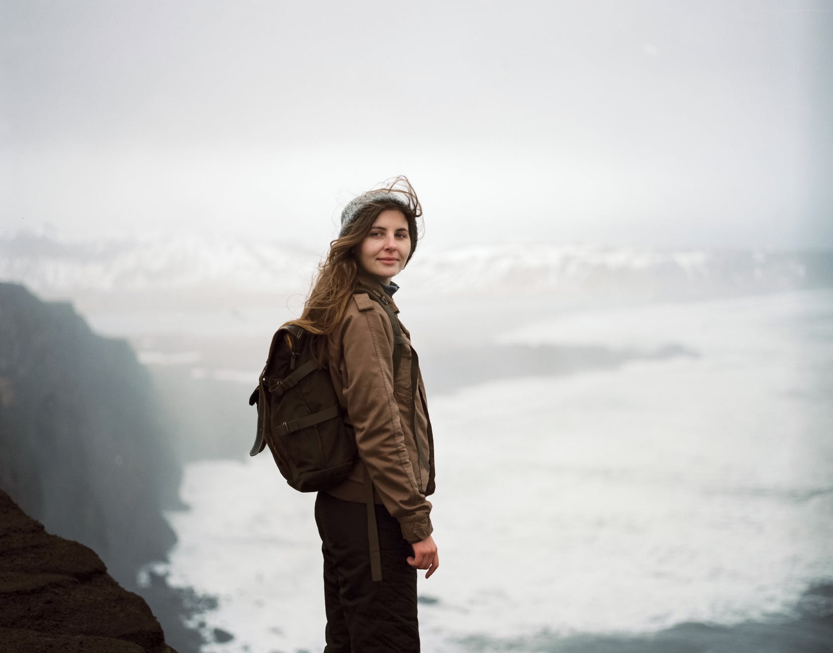 woman in brown jacket and gray knit cap